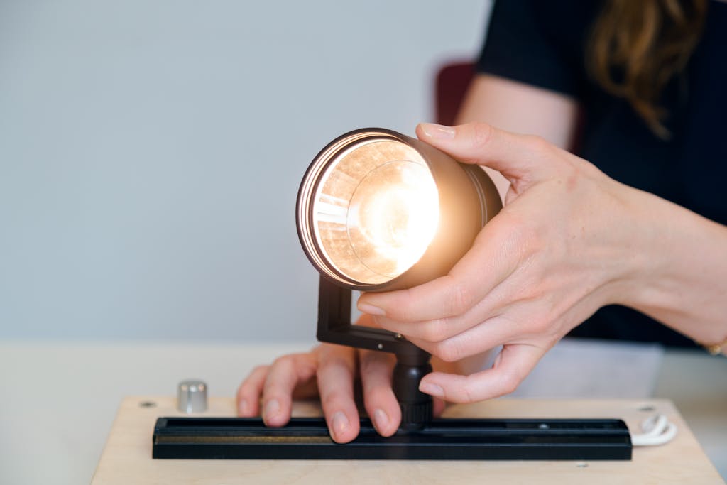 A female engineer testing a light fixture prototype in an office setting, showcasing innovation.